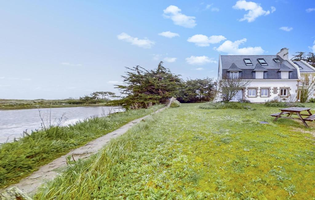 une maison au bord d'une rivière avec un banc dans l'établissement Gorgeous Apartment In Locmariaquer, à Locmariaquer