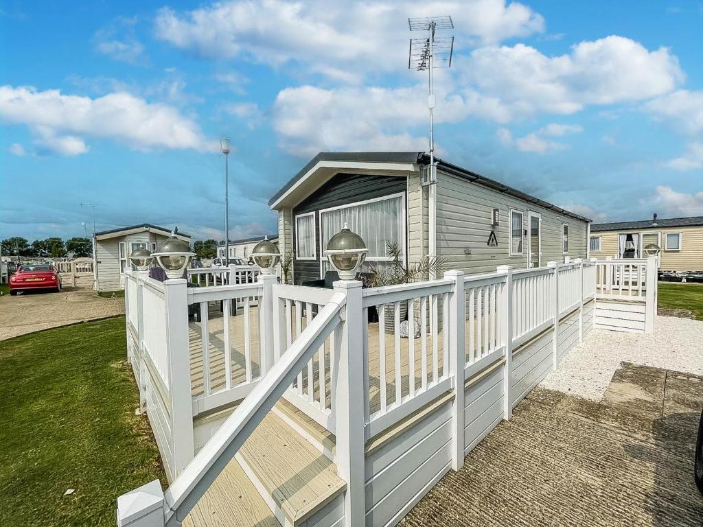 a white fence in front of a house at Modern 6 Berth Caravan With Wifi At Martello Beach In Essex Ref 28008pm in Clacton-on-Sea