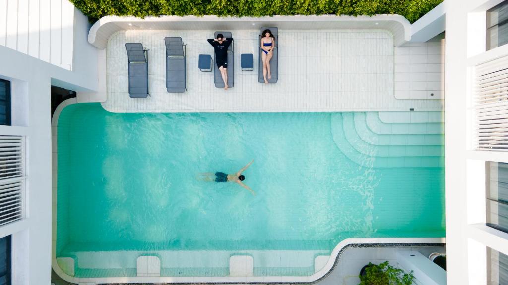 an overhead view of a swimming pool with two people in it at Saan Hotel Sathorn in Bangkok