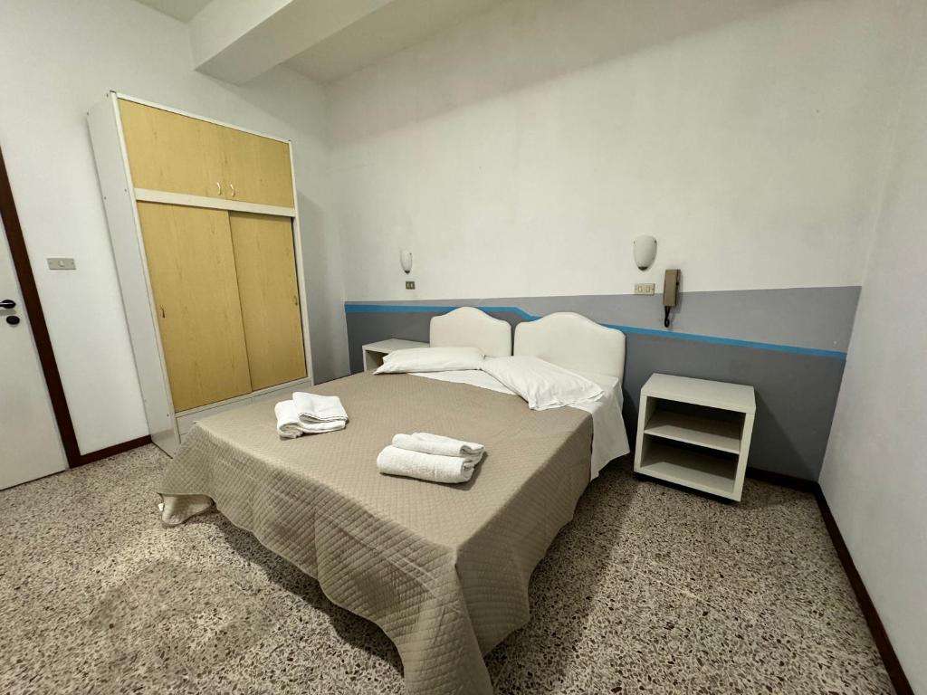 a bedroom with a bed with towels on it at Hotel Serafini in Rimini