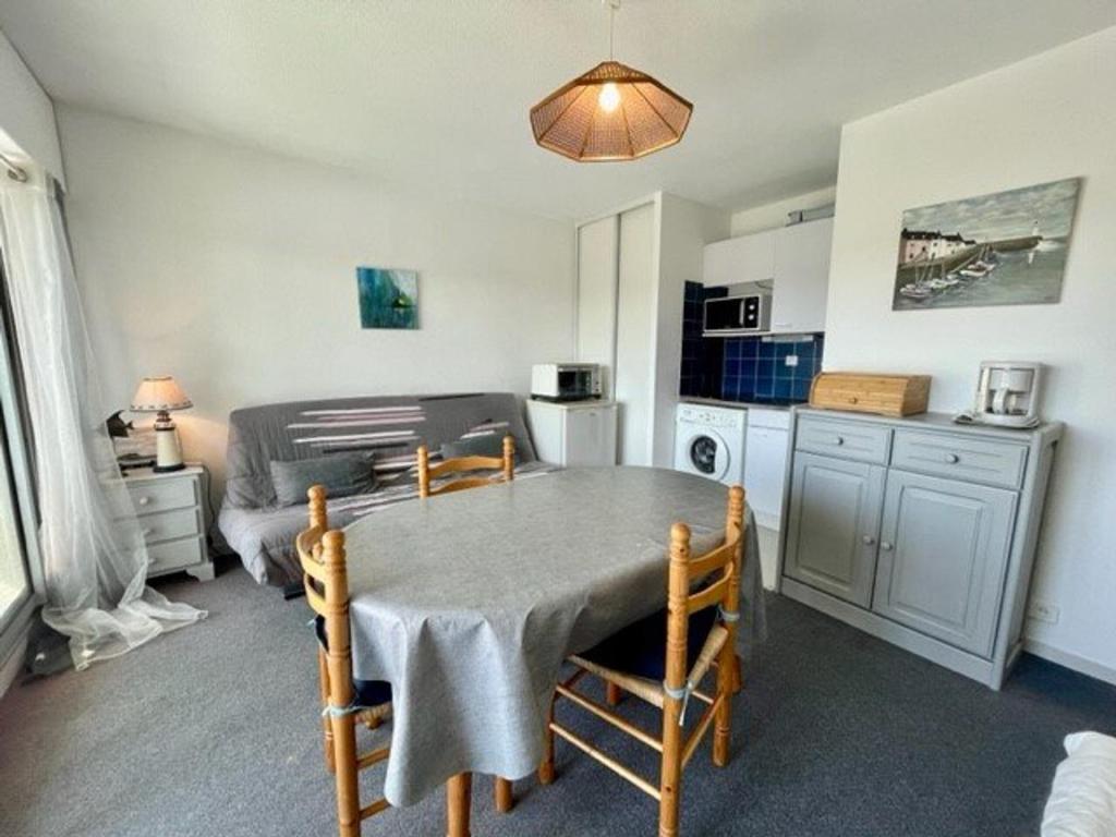 une cuisine avec une table et des chaises dans une pièce dans l'établissement Appartement 2 pièces avec balcon, piscine et parking, à 1km de la plage - Animaux acceptés - FR-1-478-27, à Quiberon