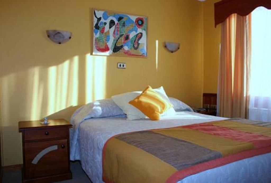 a bedroom with a bed with a wooden nightstand and a bed sidx sidx sidx at Hotel Caleta in San Miguel