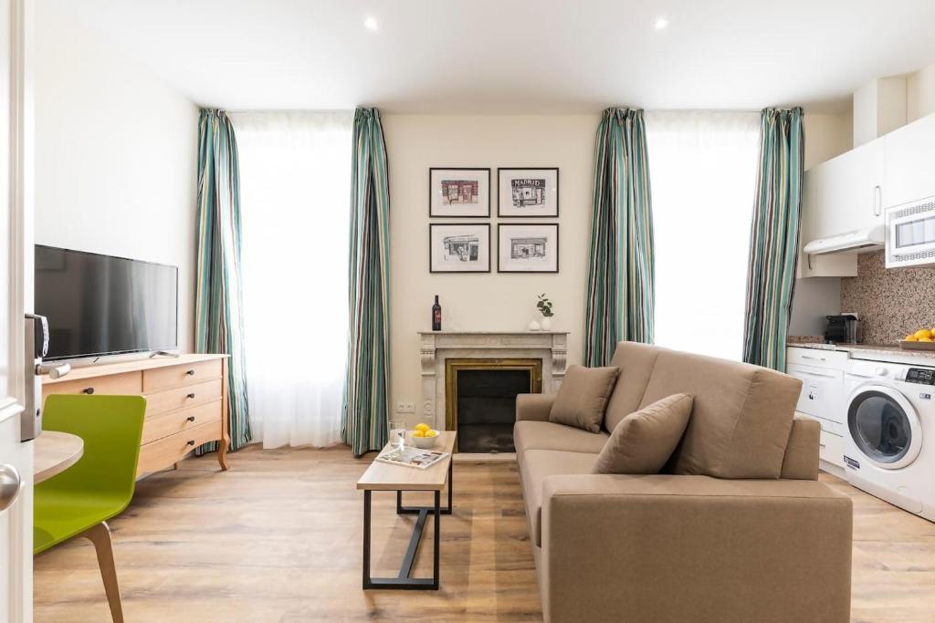 een woonkamer met een bank en een open haard bij Apartamentos Blume Conde Aranda in Madrid