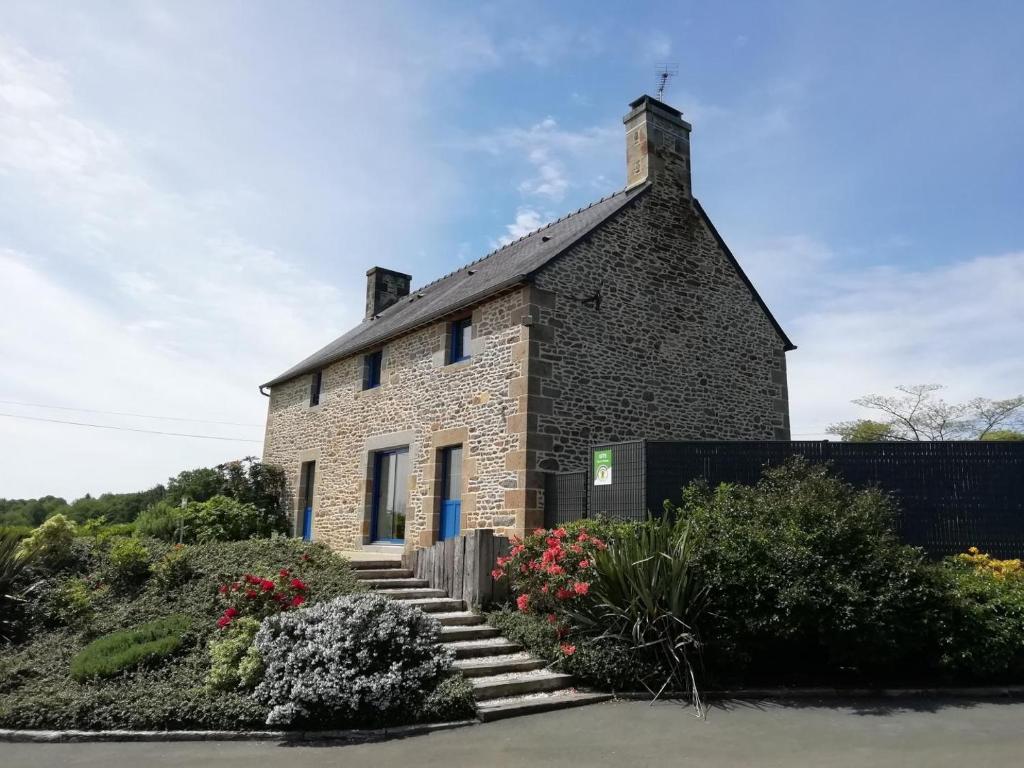 een stenen huis met een kruis op het dak bij De dartagnan in Val Couesnon
