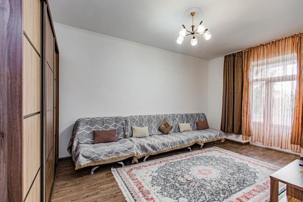 ein Wohnzimmer mit einem Sofa und einem Fenster in der Unterkunft Золотой квадрат Алматы кв32 in Almaty