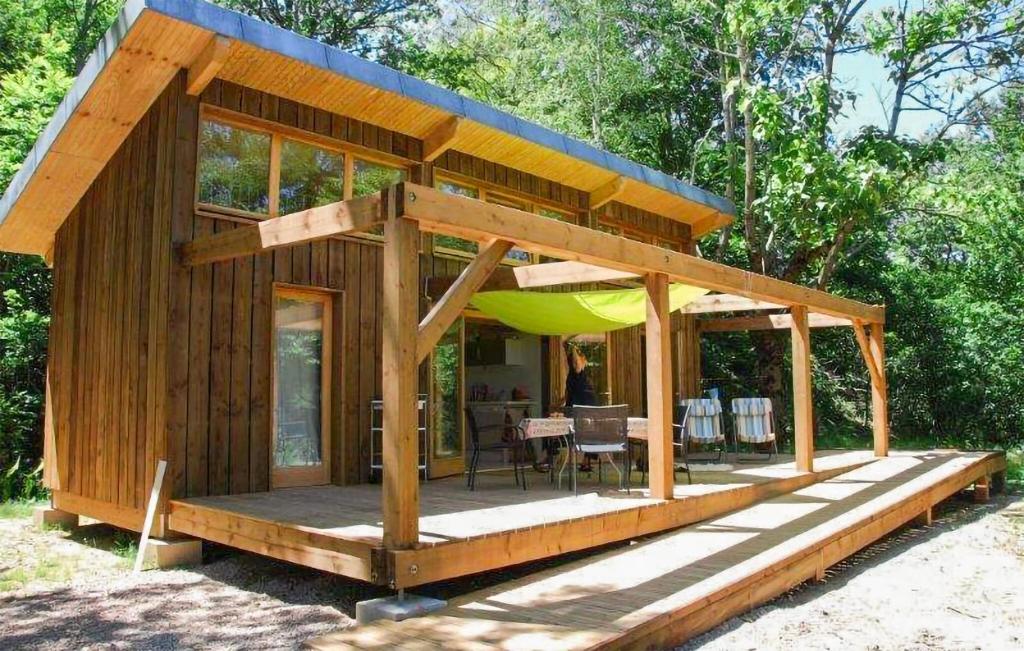 Cette petite cabane en bois comprend une table et un parasol. dans l'établissement Bamboo, à Mirandol-Bourgnounac