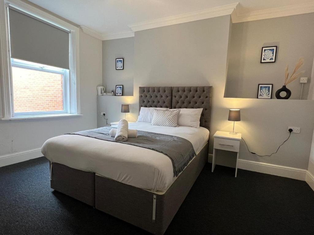 Un dormitorio con una cama grande y una ventana en Alexander Hotel, en Whitley Bay