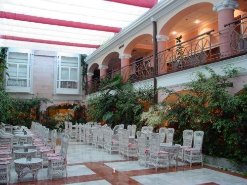 a row of white chairs and tables in a building at Hotel Begoña Park in Gijón