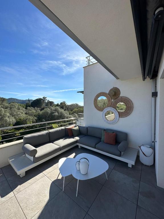 - un salon avec un canapé et une table sur un balcon dans l'établissement Domaine d'Arca - Aragon 12 - 4 pers - 2 chambres - étage 2, à Porto-Vecchio