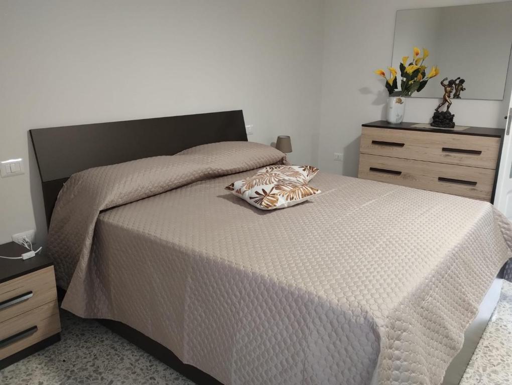 una camera da letto con un letto con una coperta bianca e due cassettiere di The Middle House a Castellammare di Stabia
