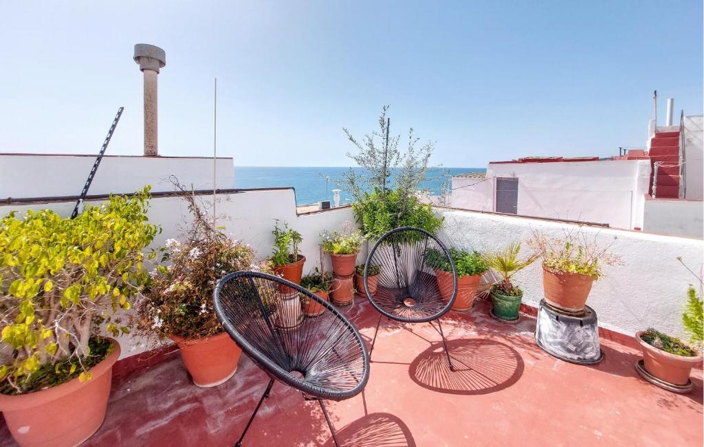 a balcony with two chairs and potted plants at Stunning Apartment In Peñíscola in Peñíscola