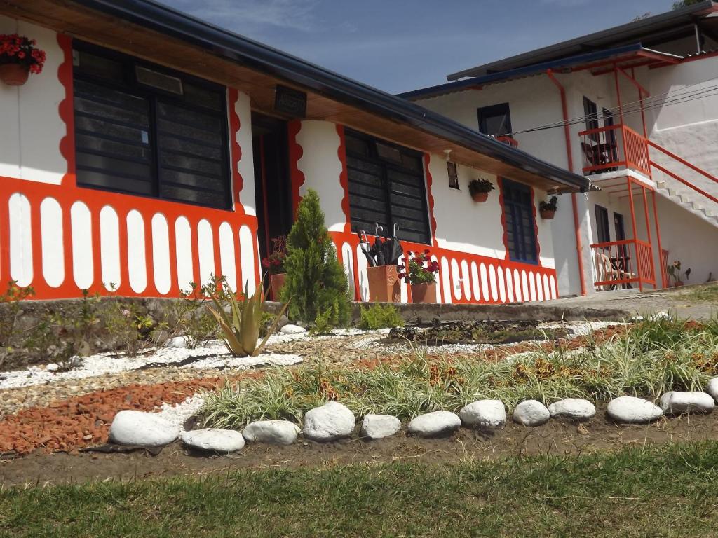 a house with a white fence and rocks in front of it at El ZORZAL in Salento