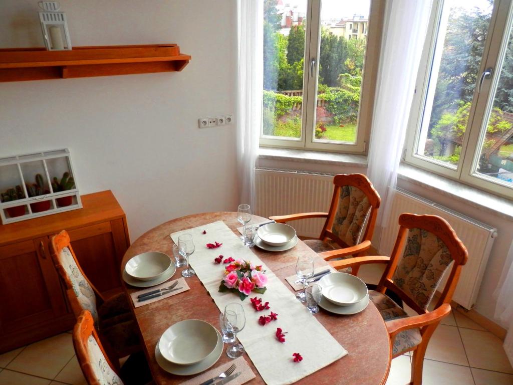 una mesa de comedor con sillas y una mesa con flores. en Spacious Apartment Below Spilberk Castle, en Brno