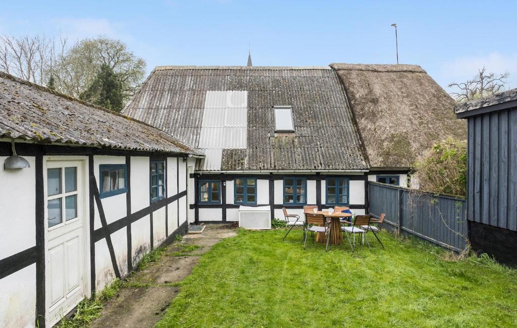 een huis met een tuin met een tafel en stoelen bij 2 Bedroom Beautiful Home In rskbing in Ærøskøbing