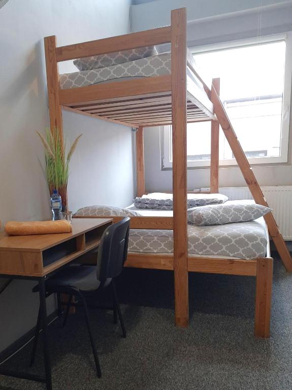 羅茲的住宿－GO Hostel Rewolucji，一间卧室配有一张桌子和一张双层床。