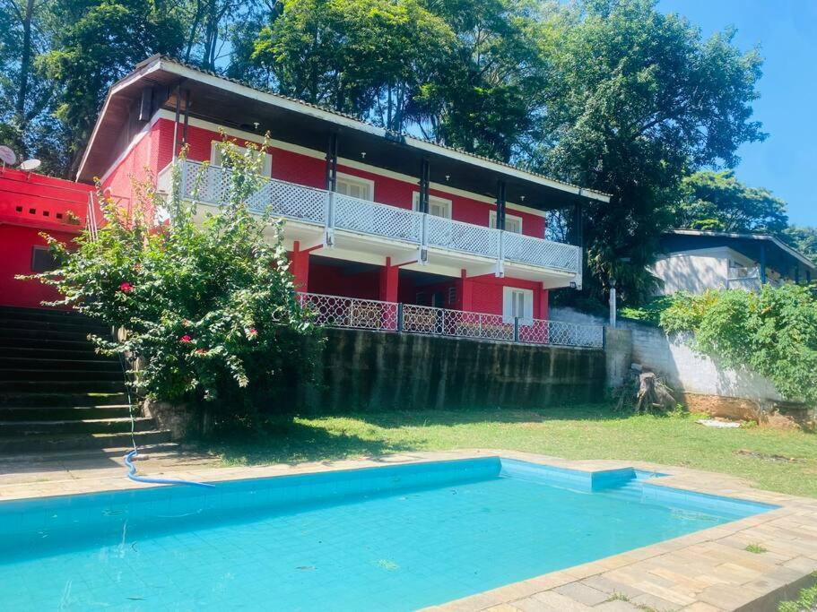 uma casa e uma piscina em frente a uma casa em Chácara com Piscina e Amplo Quintal em Embu
