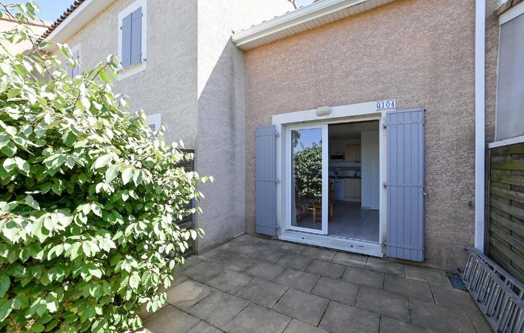eine Tür, die in ein Gebäude mit einer Terrasse führt in der Unterkunft Nice Home In Calvisson With Kitchen in Calvisson