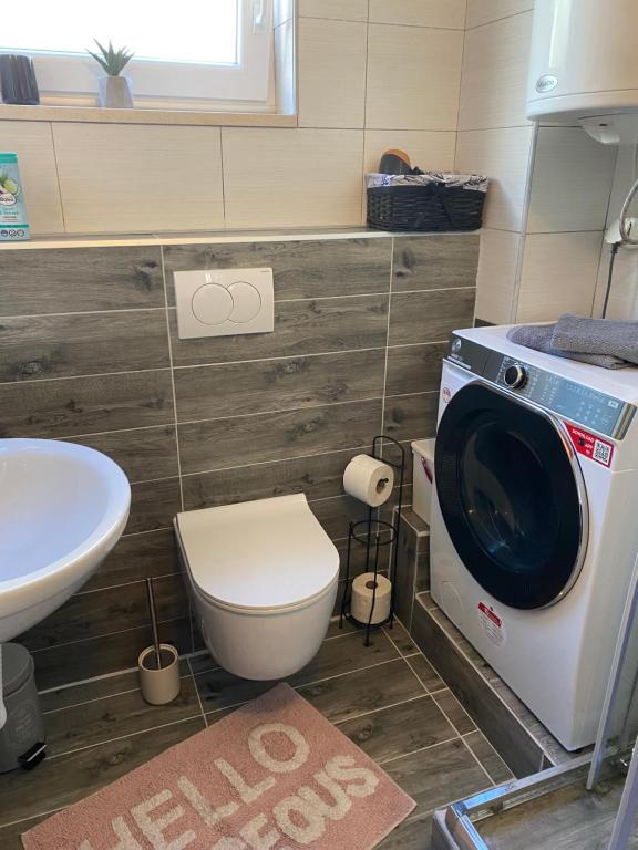 a bathroom with a washing machine and a toilet at Gabine - Self Check-in in Kaštela