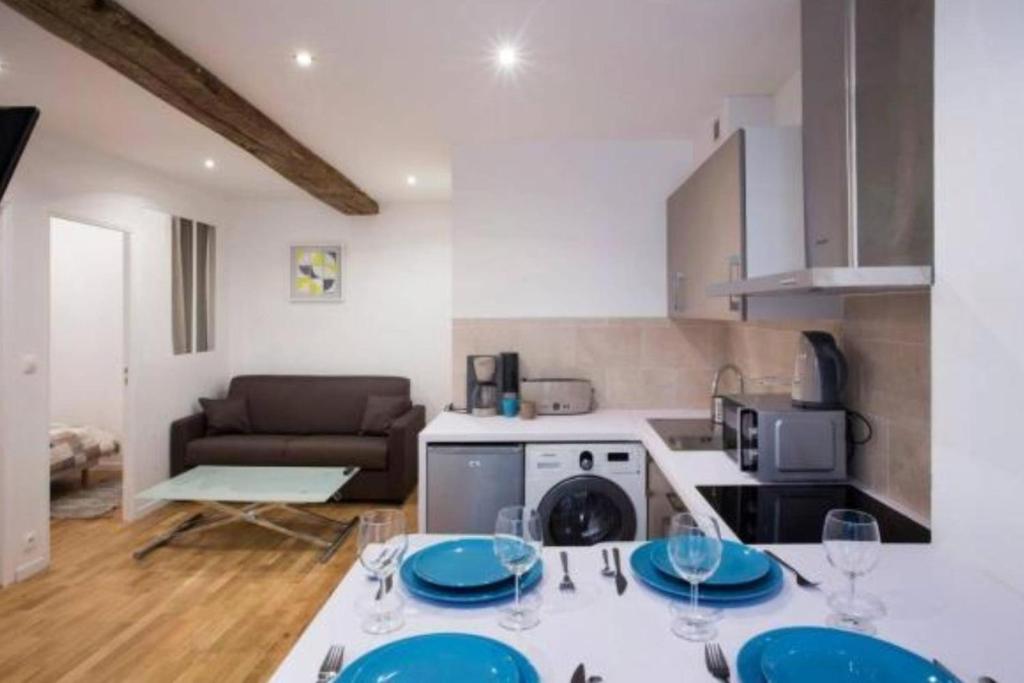 d'une cuisine avec une table et des plaques bleues. dans l'établissement Appartement confortable en plein coeur du Marais, à Paris