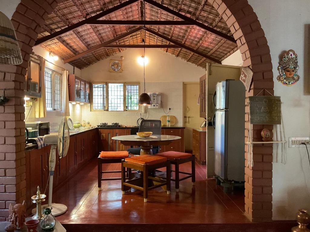 a kitchen with a table and a refrigerator at The Heritage Home Stay in Mysore