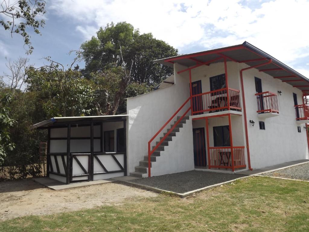 a small white house with a staircase and a balcony at El ZORZAL in Salento