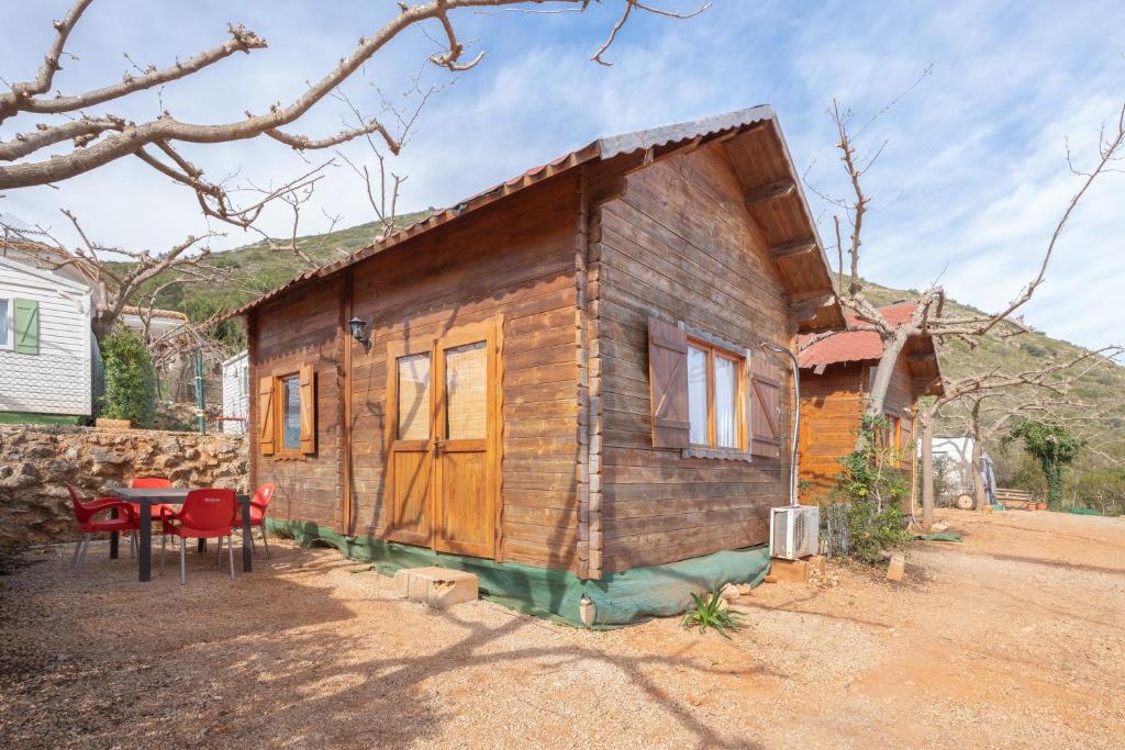 ein kleines Holzhaus mit einem Tisch davor in der Unterkunft Barraca in Bárig