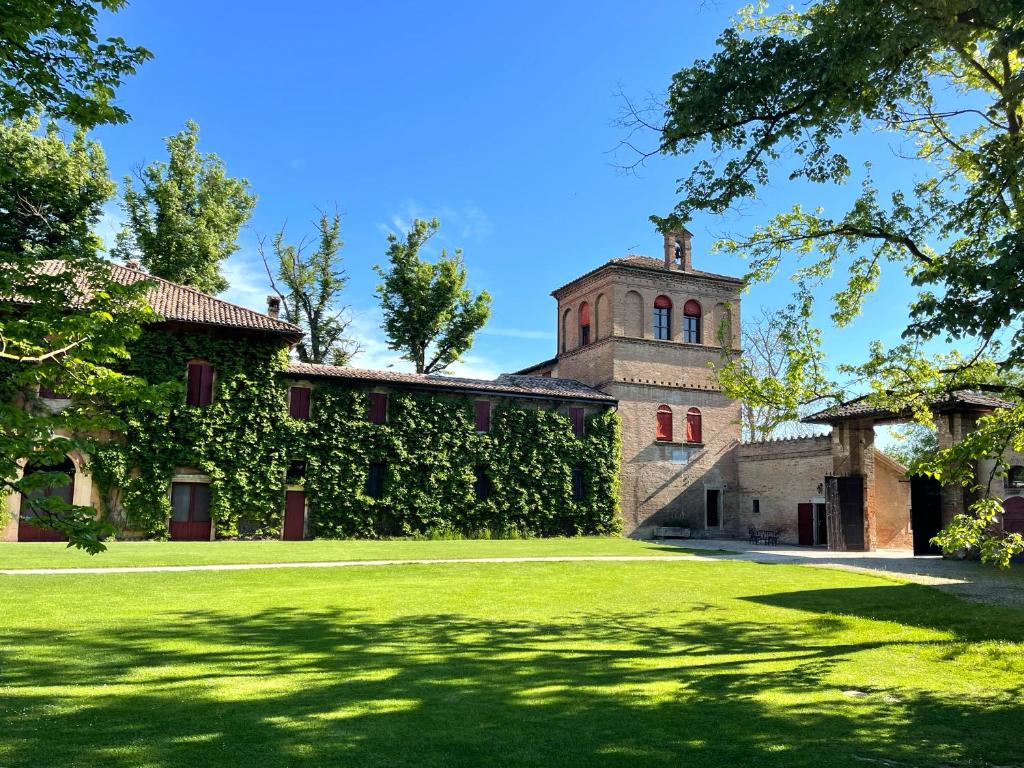 budynek pokryty bluszczem z wieżą i dziedzińcem w obiekcie Palazzo Minelli w mieście Sala Bolognese