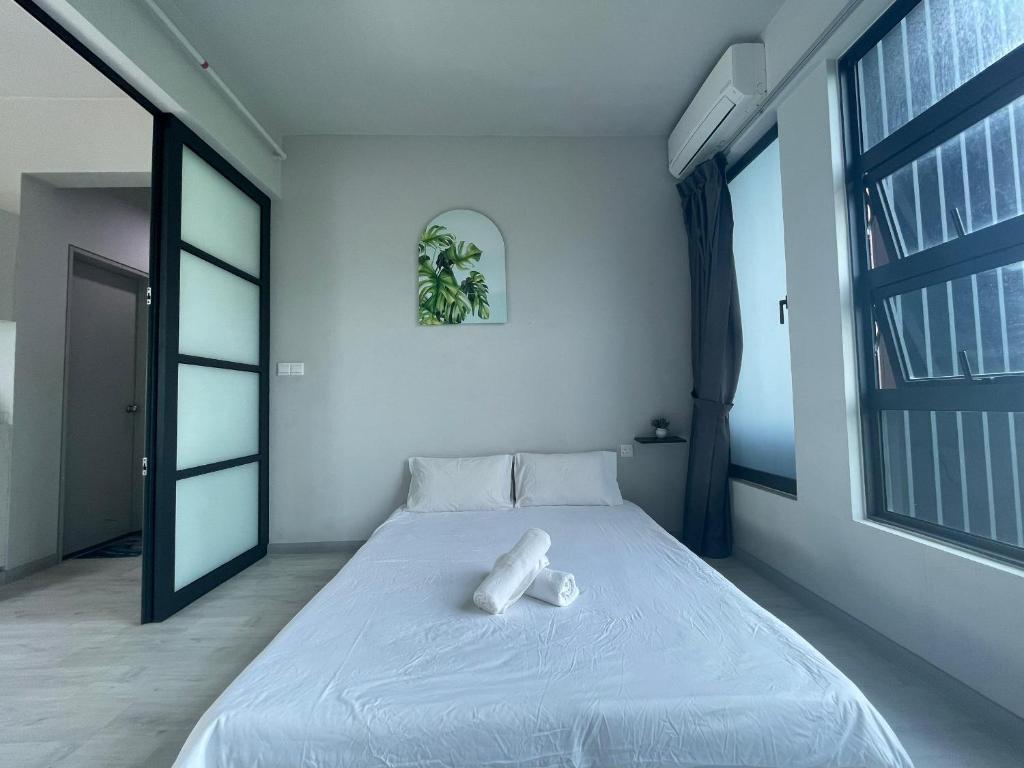 Cama blanca en habitación con ventana grande en 亲子出游首选 步行到码 Suria 家庭房带设施齐全厨房 Perfect for Family Getaways Walk to Jetty & Suria Family Room Full Kitchen, en Kota Kinabalu