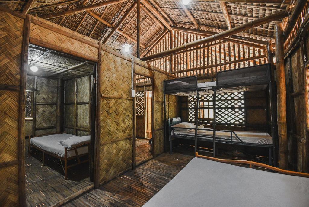 um quarto com 2 beliches numa casa de bambu em EL BOSQUE RESORT CORON em Coron