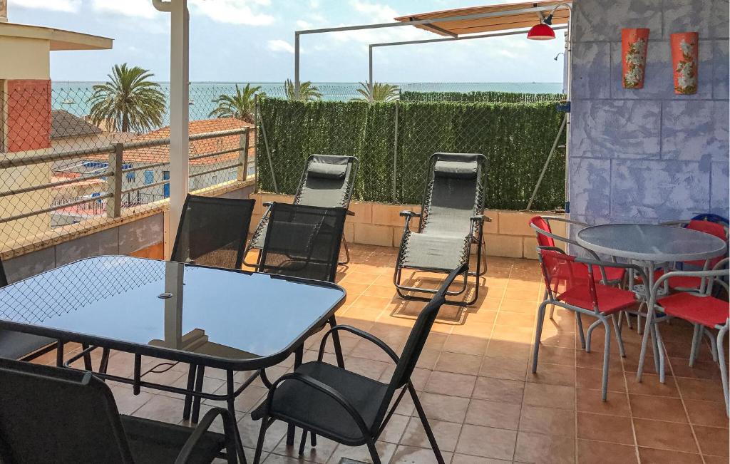 un patio con mesas y sillas y el océano en Lovely Apartment In San Javier With Wifi, en San Javier