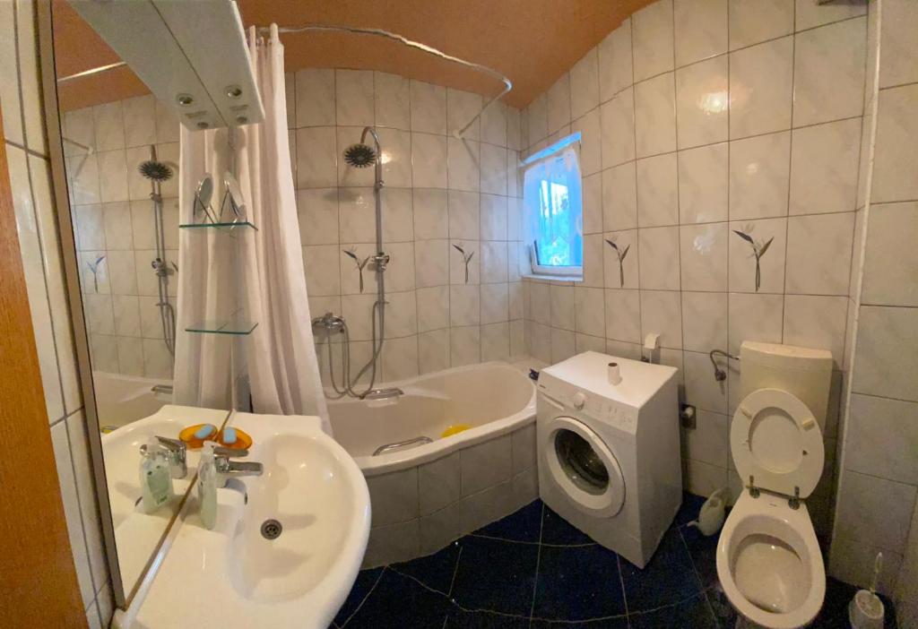 a bathroom with a sink and a toilet and a tub at Apartments-Asquiro in Raskršće