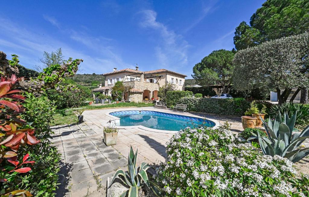 a house with a swimming pool in a garden at Lovely Home In Saint-Julien-Les-Rosie in Saint Julien Les Rosiers