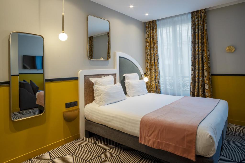 a hotel room with a bed and a mirror at Hotel Elysa-Luxembourg in Paris
