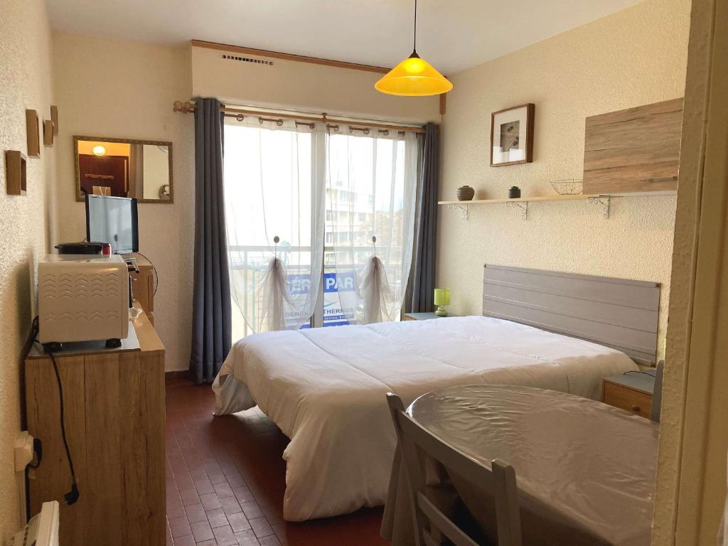 1 dormitorio con 1 cama, TV y ventana en Studio Balaruc-les-Bains, 1 pièce, 2 personnes - FR-1-553-80, en Balaruc-les-Bains