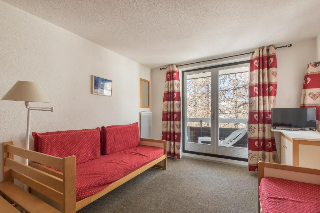 un salon avec un canapé et une fenêtre dans l'établissement Eyssina - Station de ski accessible à pied, à Vars