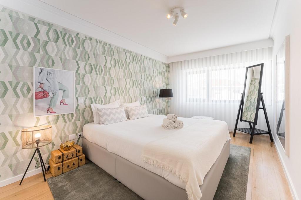 1 dormitorio con cama blanca y pared en GuestReady - Geometric Dawn in Vila do Conde, en Vila do Conde
