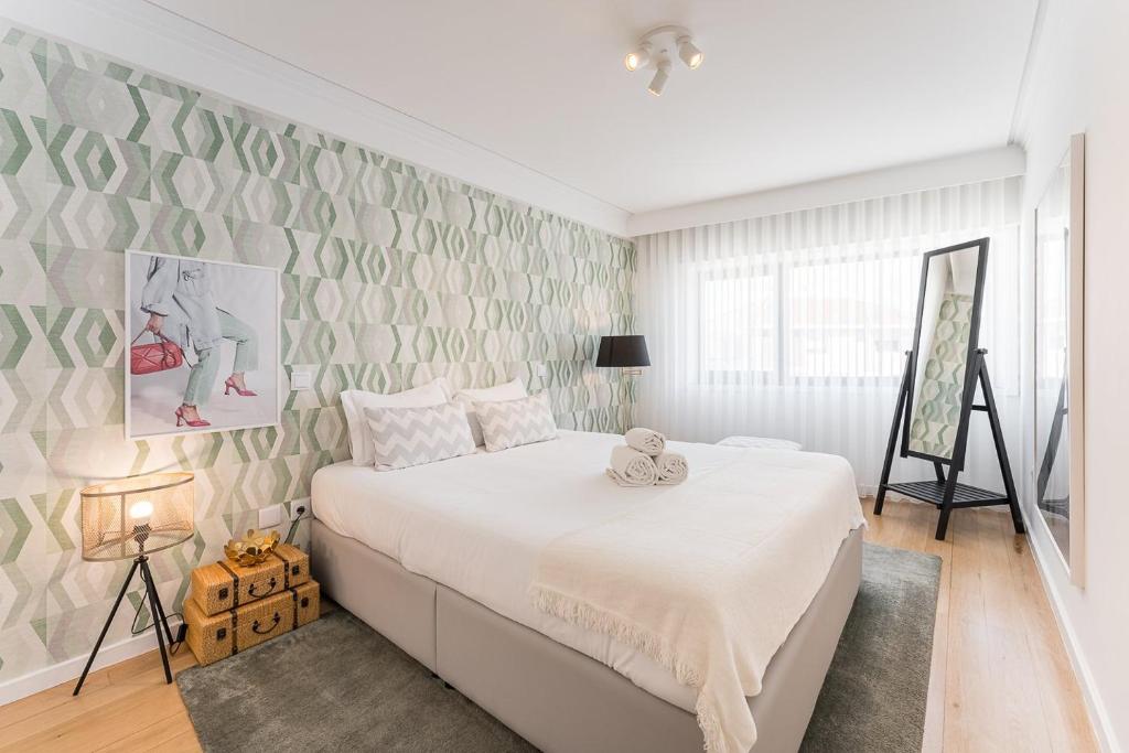 a bedroom with a white bed and a wall at GuestReady - Geometric Dawn in Vila do Conde in Vila do Conde