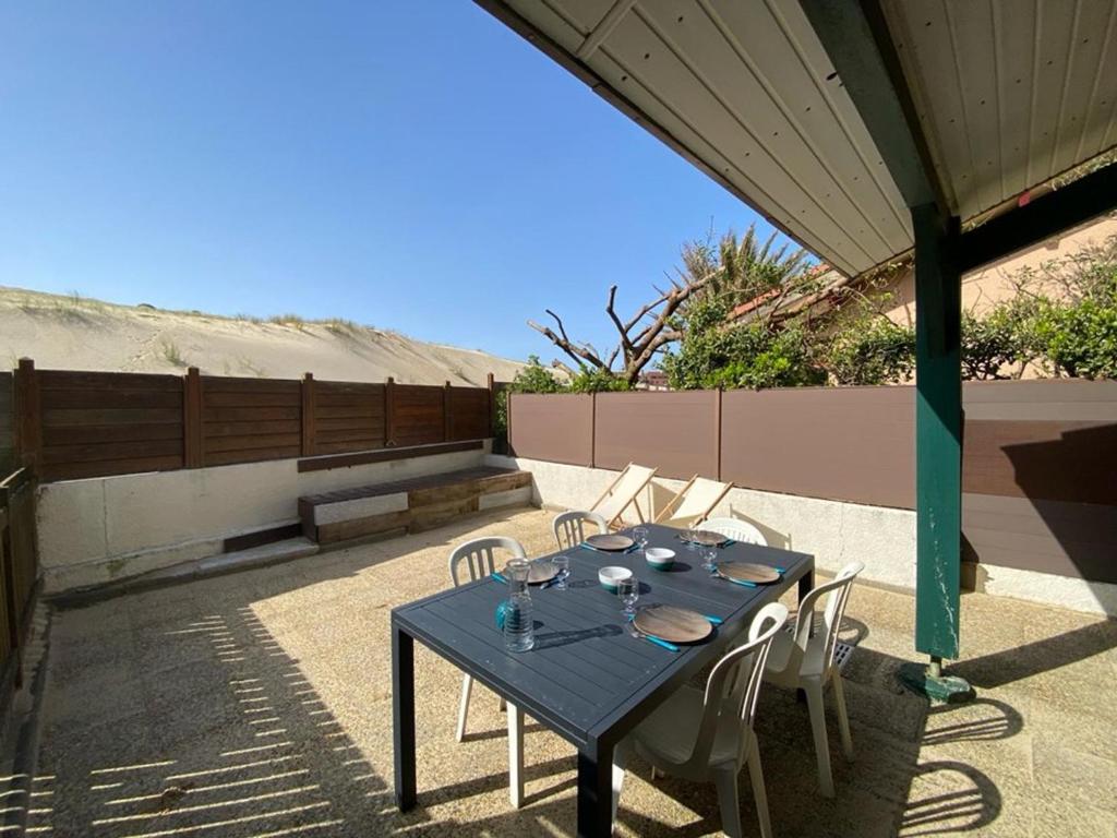 une table et des chaises bleues sur une terrasse dans l'établissement Maison à Capbreton: 20m plage, terrasse, parking, animaux ok - FR-1-413-159, à Capbreton