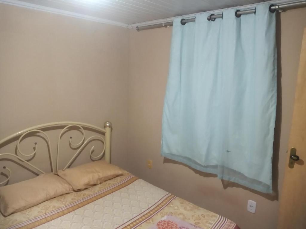 Dormitorio pequeño con cama con cortina en Residencial Barbosa - Apto 302 en Macaé