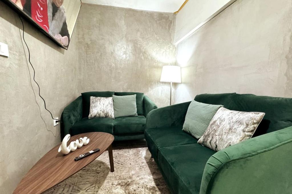 ein Wohnzimmer mit 2 grünen Sofas und einem Couchtisch in der Unterkunft Tranquil refuge in Xalapa, 3BR 1BA apt for 6 in Xalapa