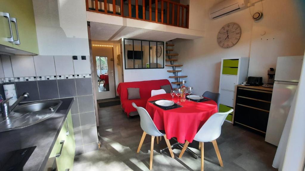 une cuisine avec une table et un chiffon rouge dans l'établissement Appartement 2 pièces mezzanine avec piscine, au Cap d'Agde