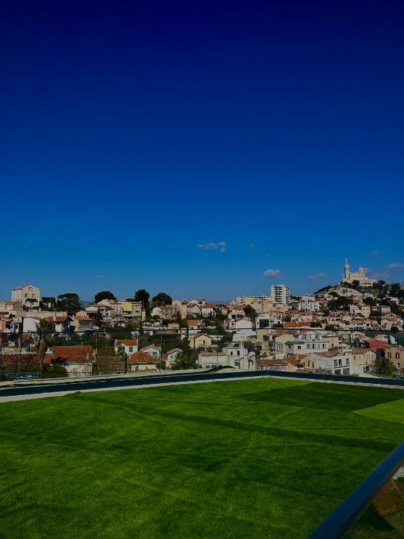 a green field with a city in the background at Maï Homes - La Villa Bompard in Marseille