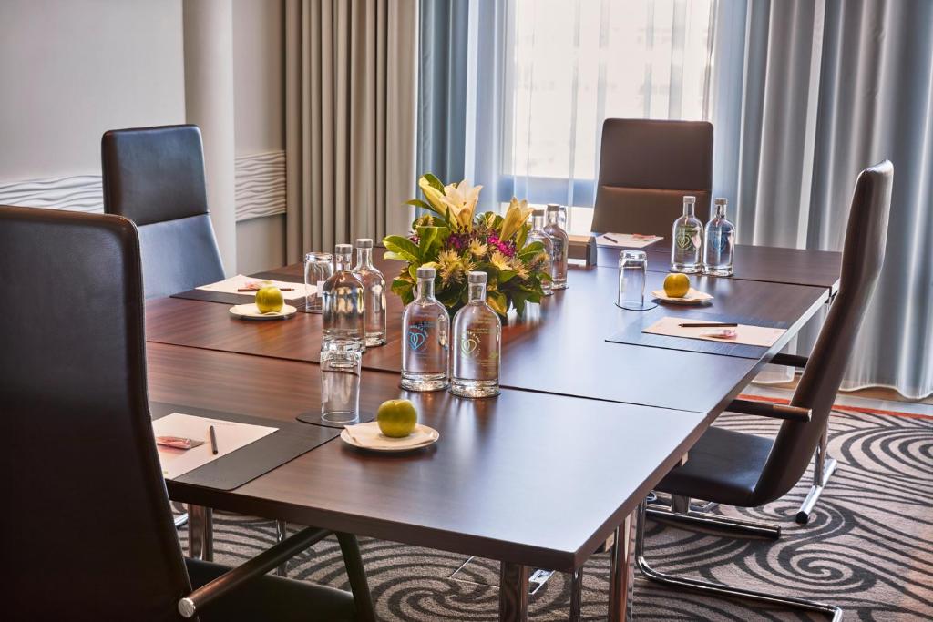 a conference room with a table with bottles and flowers at Steigenberger Hotel Bremen in Bremen