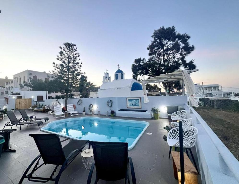 - une piscine sur une terrasse entourée de chaises dans l'établissement Villa Anto, à Fira