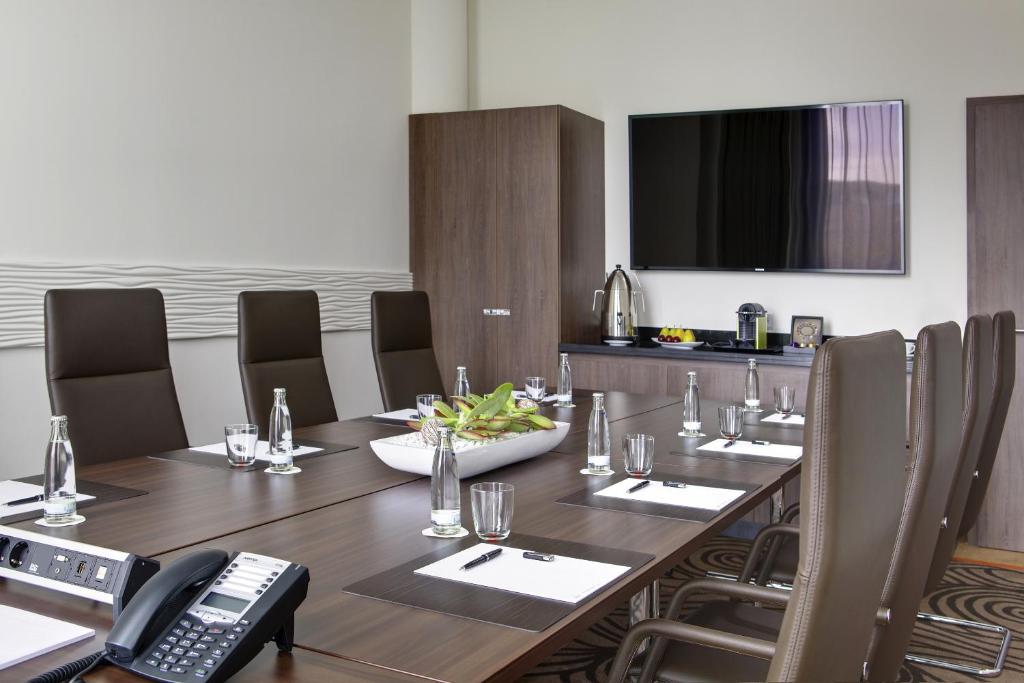 a conference room with a table and a phone at Steigenberger Hotel Bremen in Bremen
