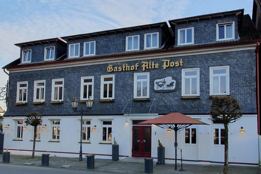 a large black and white building with a red door at Alte-post in Wissen