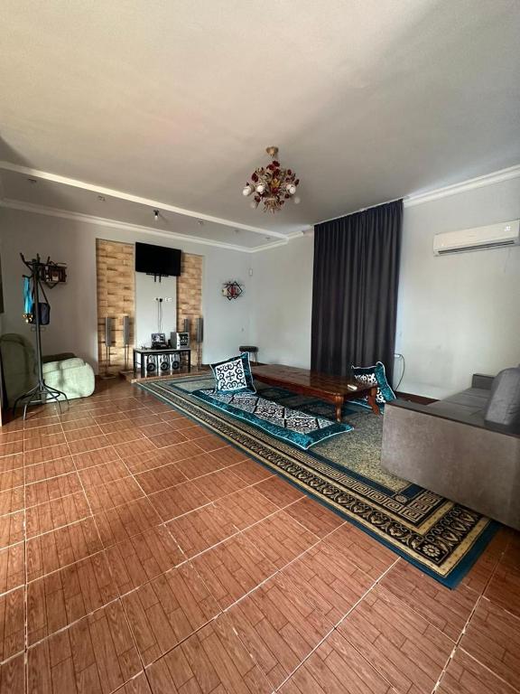 Хостел Aspan في ألماتي: غرفة معيشة مع أريكة وطاولة