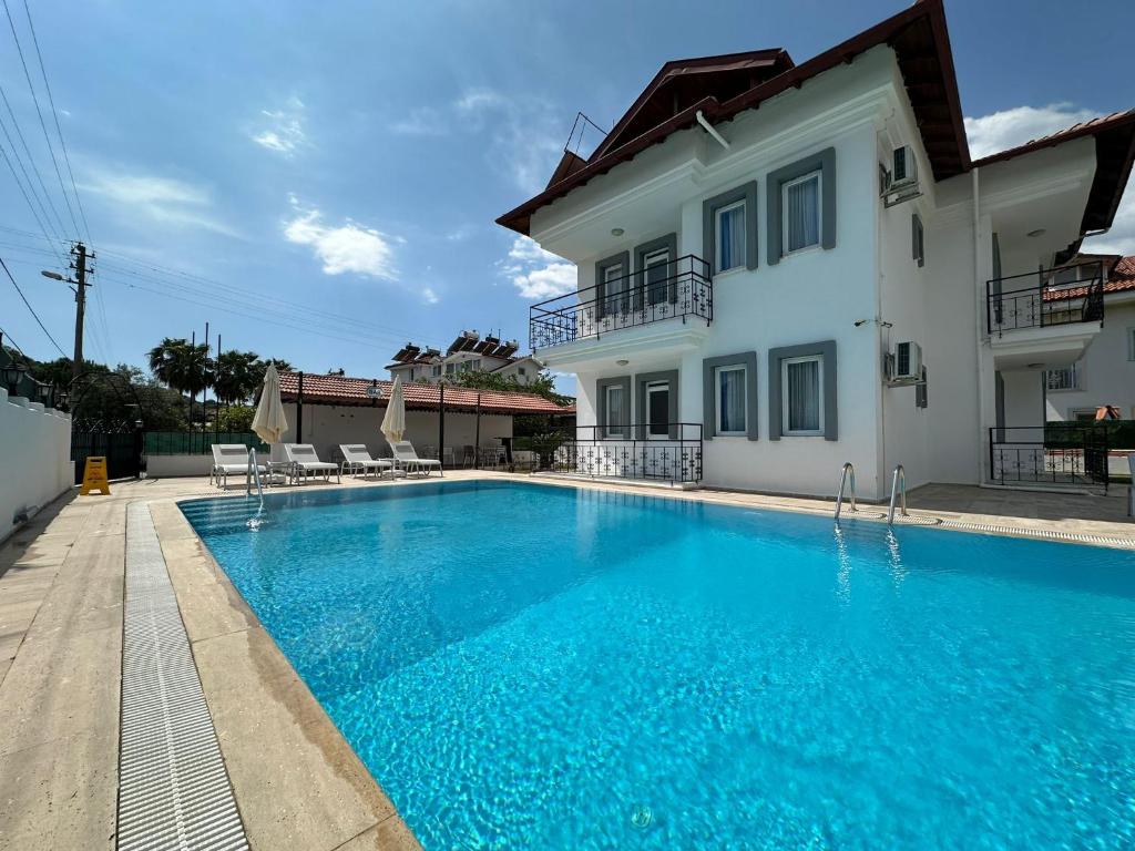a swimming pool in front of a house at Stay Dalyan Apart Hotel in Ortaca