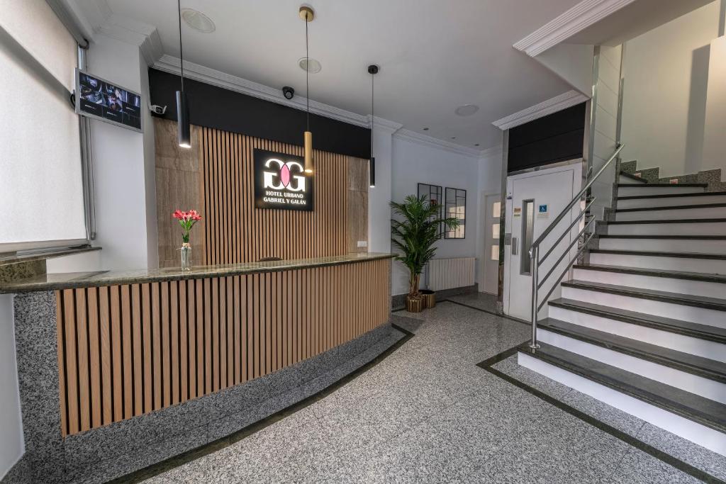 Un vestíbulo con escaleras y un cartel que dice en Hotel Gabriel y Galán, en Salamanca