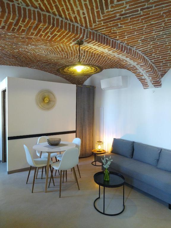 un salon avec un canapé, une table et des chaises dans l'établissement chez Angèle, à Aléria